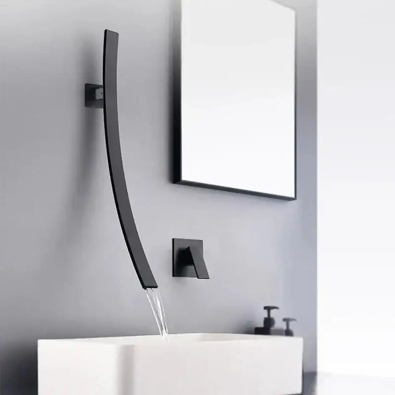 Modern matte black bathroom faucet set with curved waterfall spout mounted on gray wall above white sink faucet set