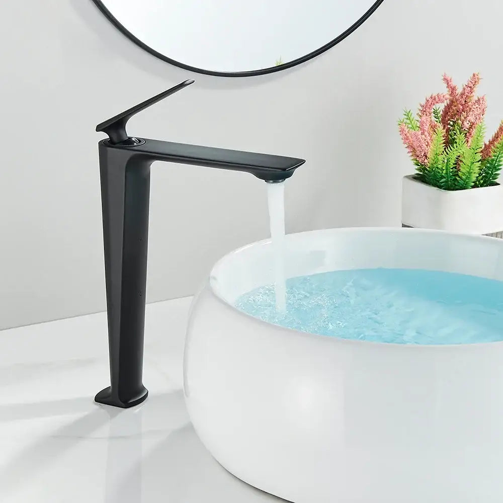 Modern matte black bathroom faucet set with sleek minimalist spout flowing water into a white ceramic vessel sink