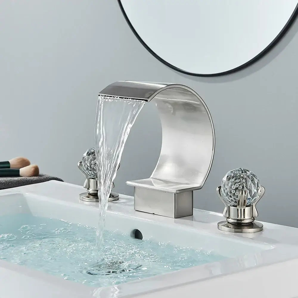 Modern matte black bathroom faucet set featuring a sleek curved metallic waterfall faucet with crystal-encrusted handles