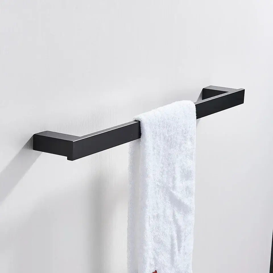 Modern matte black bathroom hardware set featuring a square black matte metal towel rack with a white terry cloth towel