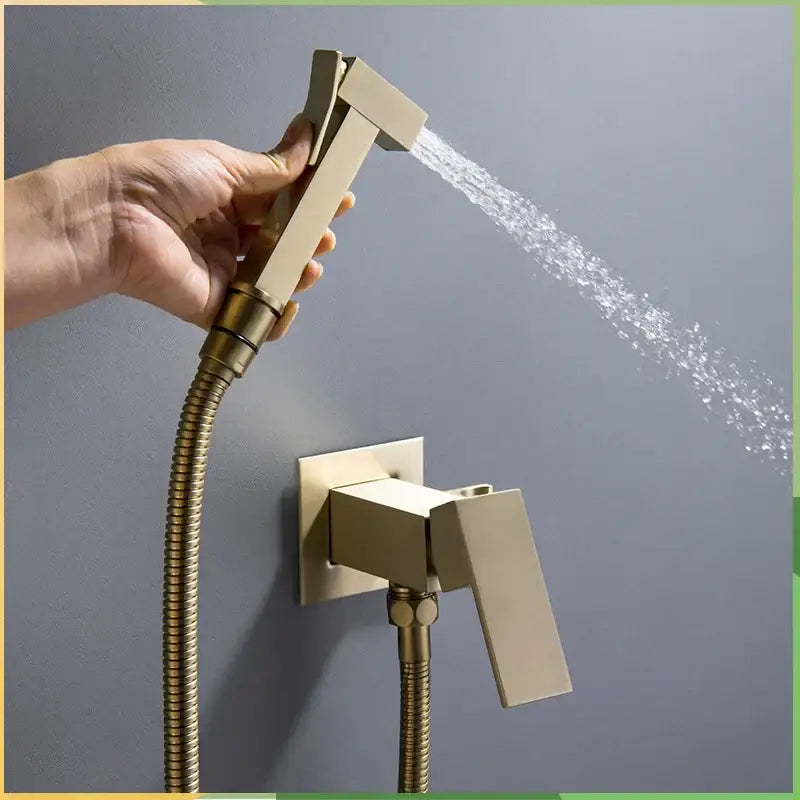 Modern brushed brass handheld bidet faucet shower sprayer with sleek rectangular design and flexible braided hose
