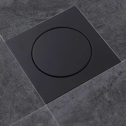 Modern matte black brass shower floor drain with circular recessed center set in dark gray tiled flooring decorbites brass shower