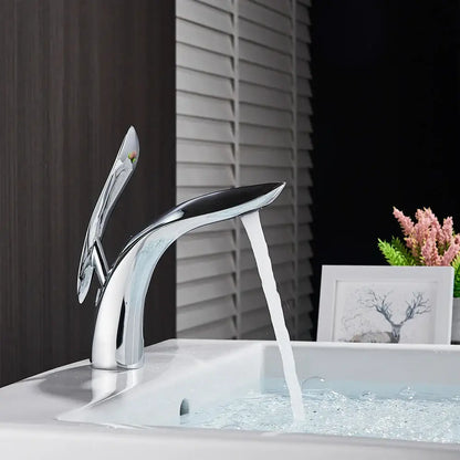 Modern chrome-finished decorbites brass washbasin faucet with sleek sculptural design and single spout handle for bathroom use