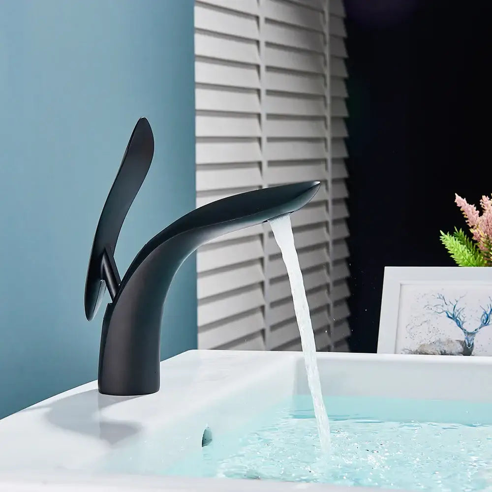 Modern matte black brass washbasin faucet with sleek curved design and waterfall spout by decorbites brass washbasin