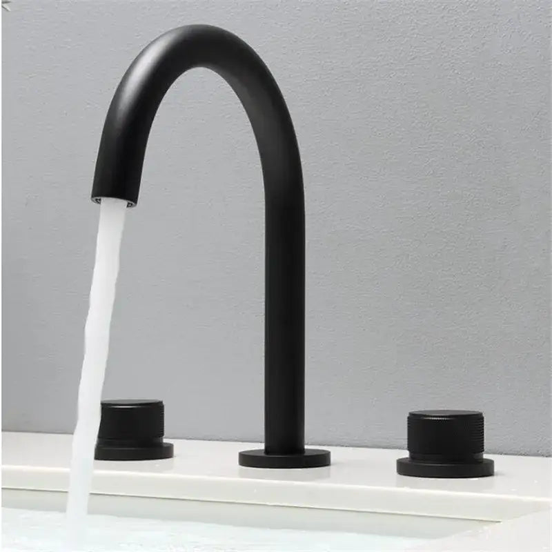 Modern matte black basin faucets with curved spout and brushed gold basin handles for bathroom sink