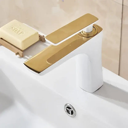 Gold-finished modern decorbites basin faucet with sleek rectangular spout and handle on white ceramic sink