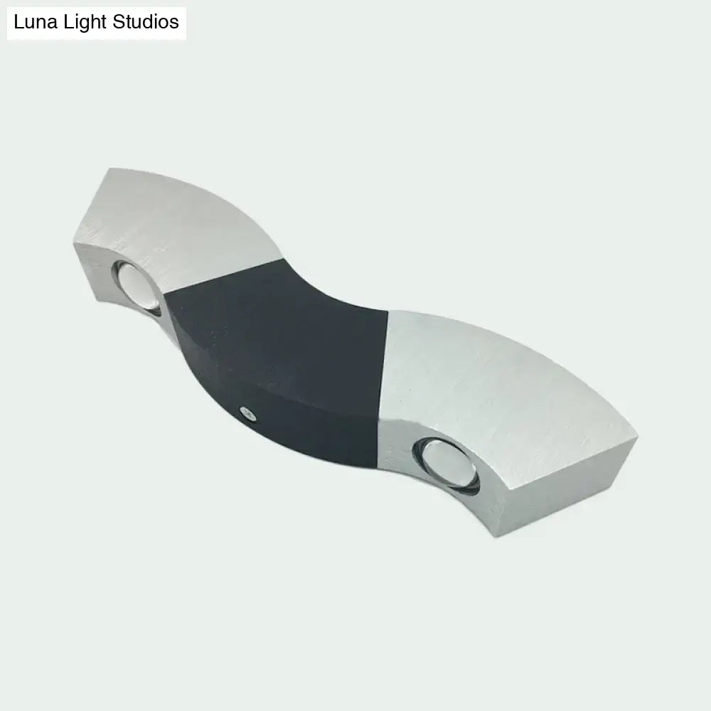 Modern matte black and gray sconce light with silver aluminum wave design and warm white lighting for bedroom use