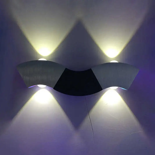 Modern matte black and gray sconce light with aluminum wave design featuring warm white lighting and a sleek curved form