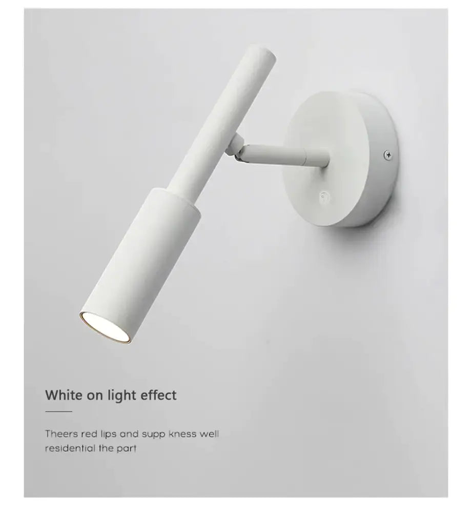 White minimalist wall lamp reading with sleek cylindrical design and adjustable arm for modern bedroom lighting