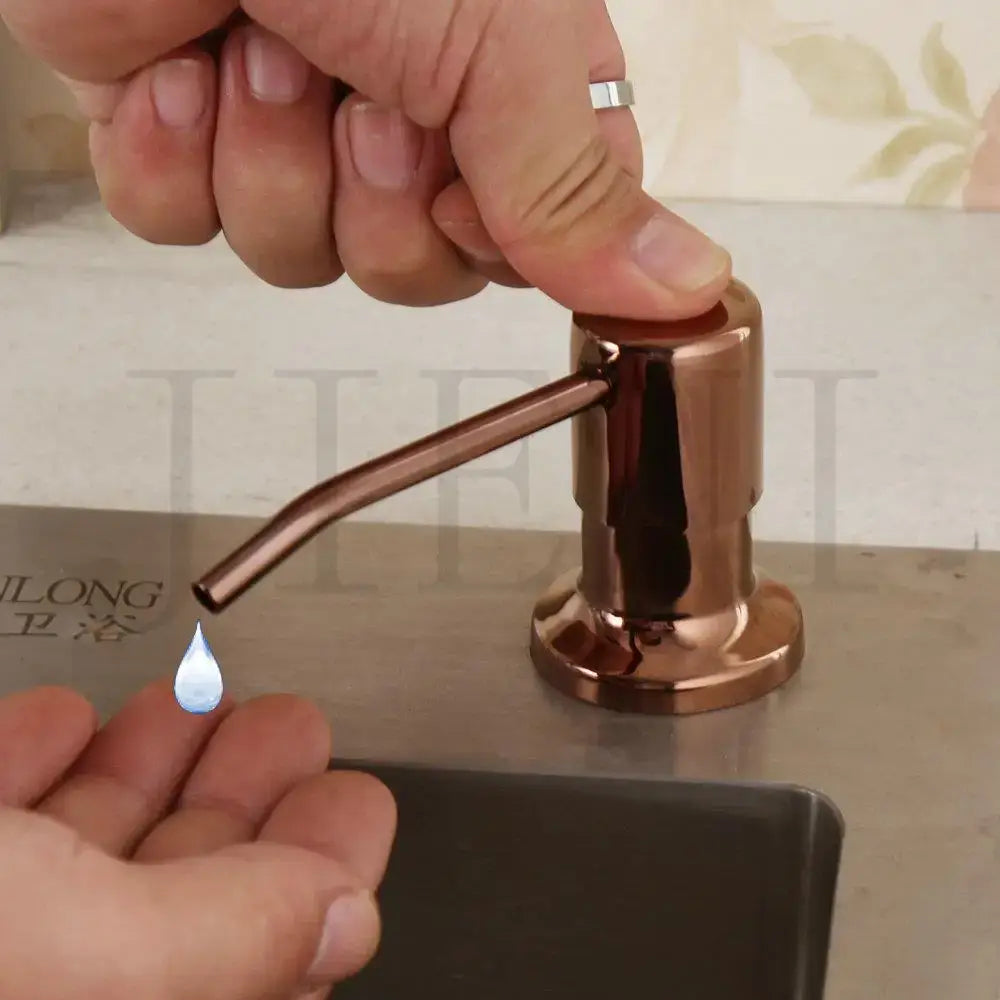 Rose gold finished metal soap dispenser with sleek cylindrical body and curved spout for liquid soap by decorbites grey rose