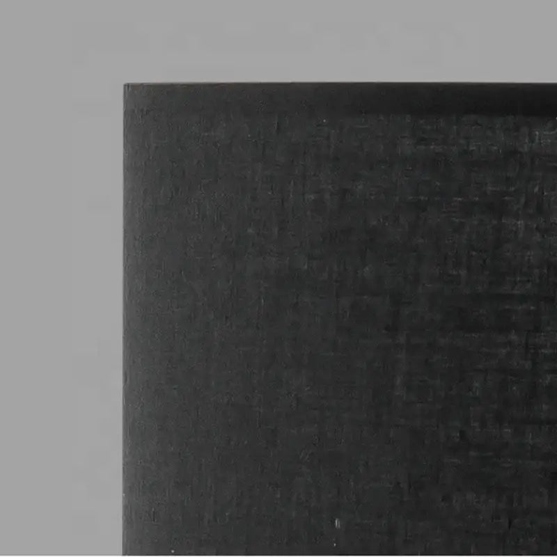 Black carbon fiber panel with textured woven surface on modern matte black metal table lamp for living room decorbites designer