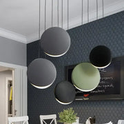 Modern matte black and muted green crescent moon chandelier with minimalist pendant lights by decorbites for dining room decor