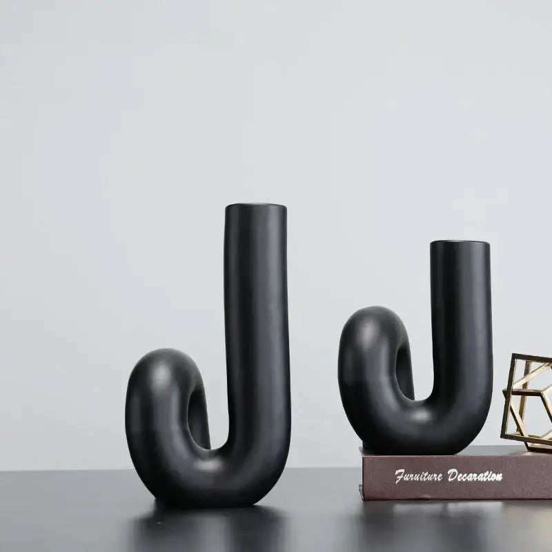 Two sleek matte black ceramic vases with abstract u-shaped twist knot design for modern black pipe geometric decorbites decor