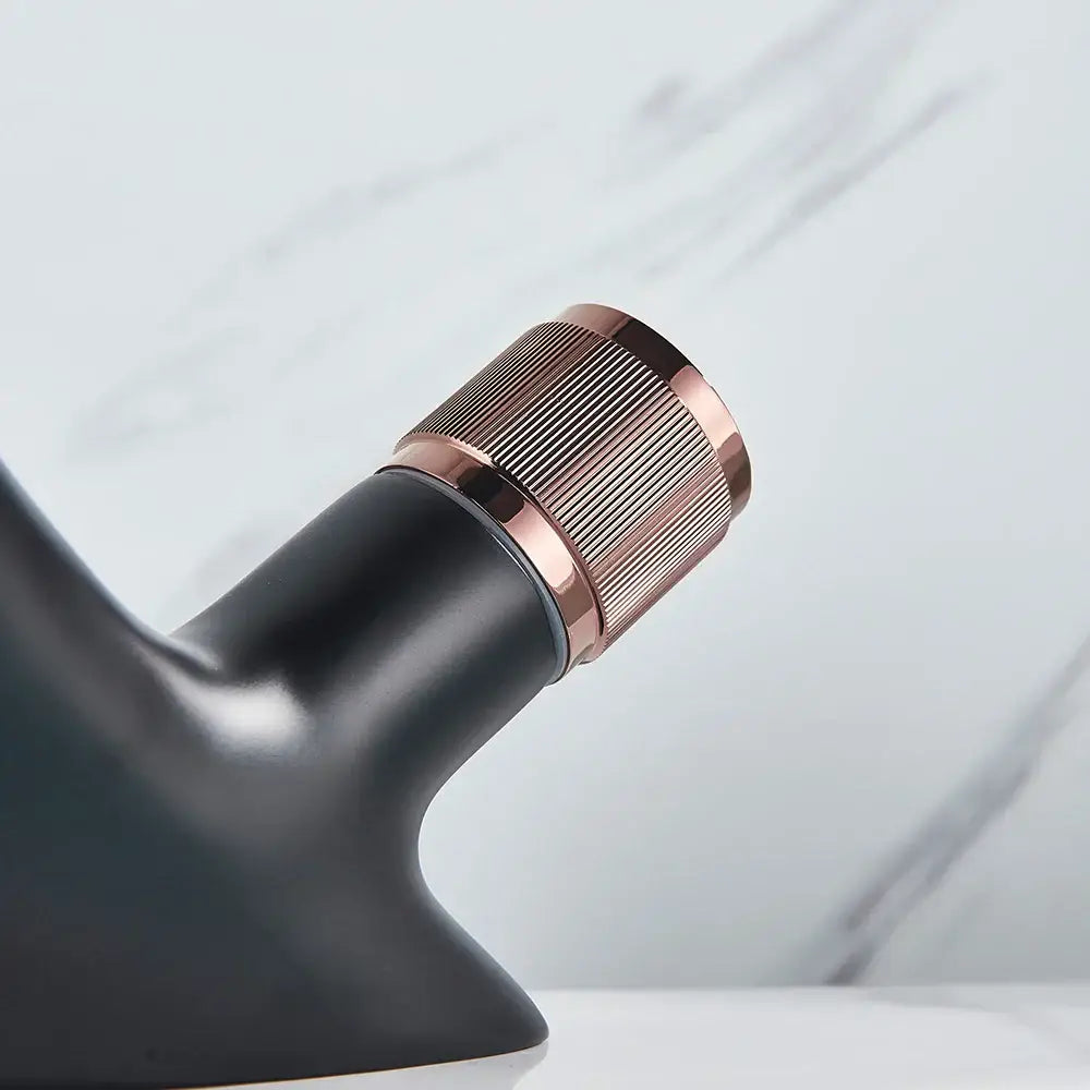 Modern matte black and rose gold brass basin faucet featuring a black brass basin design with a textured knob by decorbites