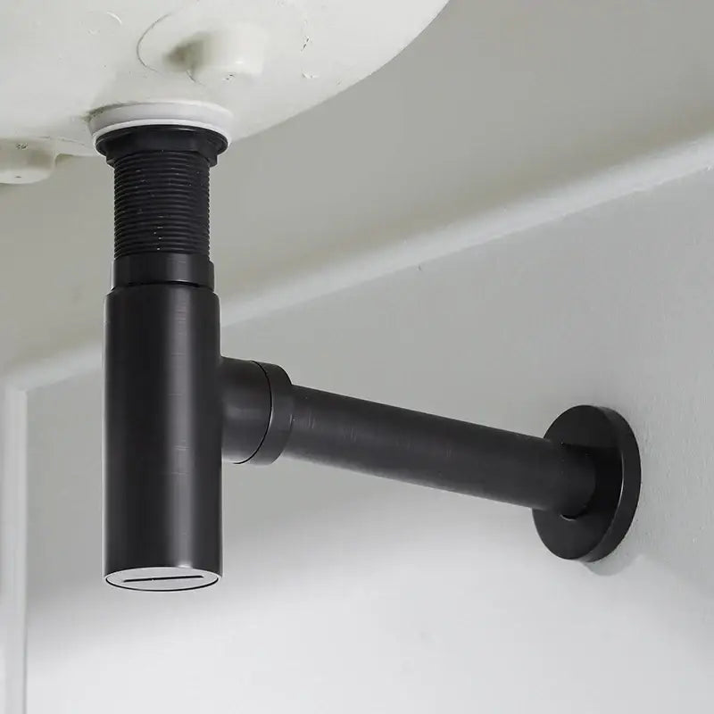 Modern matte black round bottle trap with black matte-finished under-sink drain pipe and threaded connection seen from back side