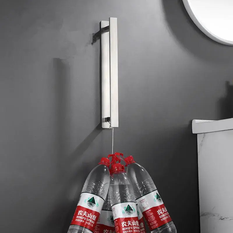 Silver metallic wall-mounted towel rack with sleek minimalist design holding clear bottles by decorbites black steel