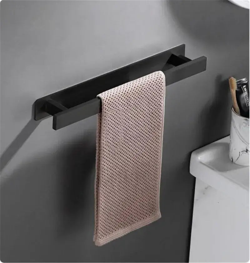 A sleek matte black steel towel rack holds a soft blush pink microfiber hand towel for modern bathroom decorbites towel hanger