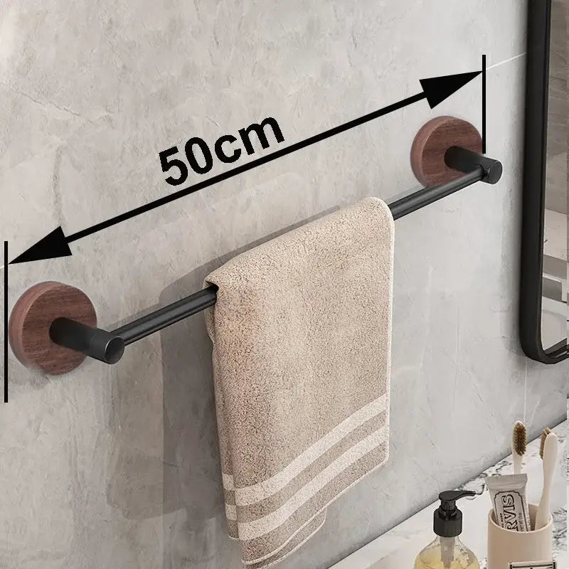 Modern matte black wall mounted towel bar with wood accents holding a beige textured towel on a black wall mounted rack