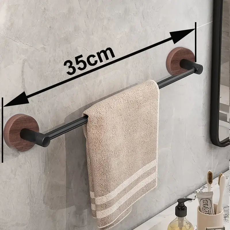 Modern matte black wall mounted towel bar with wooden circular ends holding a beige striped towel in bathroom