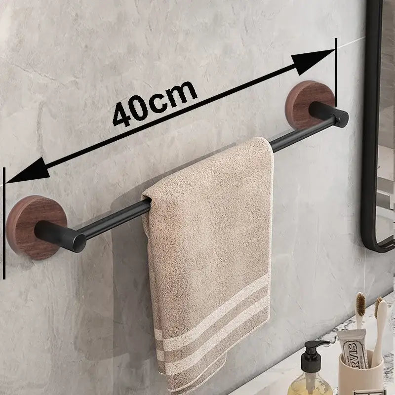 Modern matte black wall mounted towel bar with wooden mounts holding a beige textured towel for bathroom use