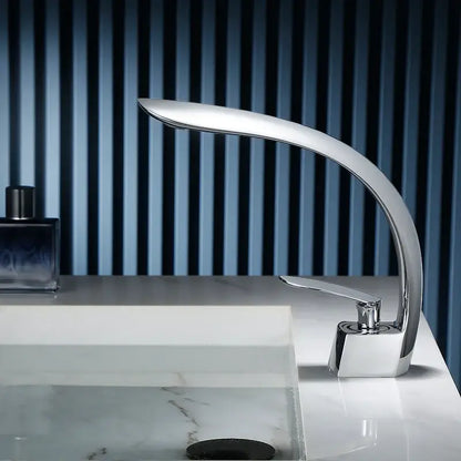 Modern chrome-finished waterfall basin faucet with sleek curved design and single handle mixer for bathroom use
