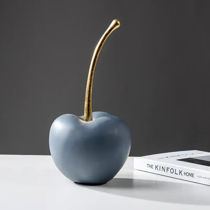 A sleek matte blue resin apple ornament with a polished gold stem for modern living room decor