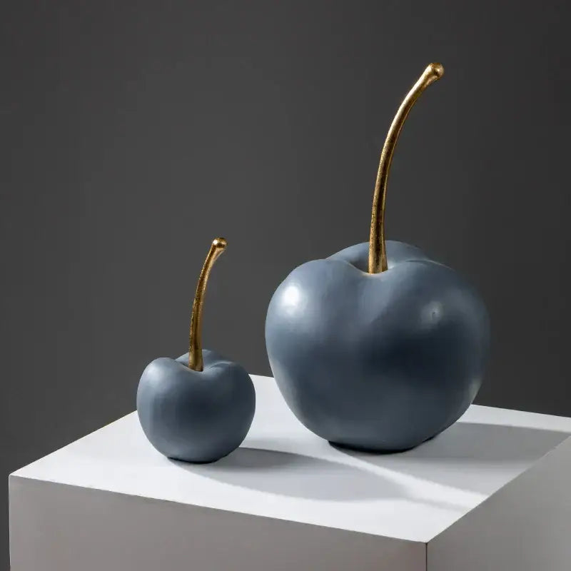 Two matte blue resin apple ornaments with gold toned stems for modern living room decor
