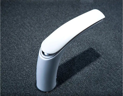 Modern white ceramic basin faucet with sleek curved spout and polish chrome accents in brass baking finish by decorbites