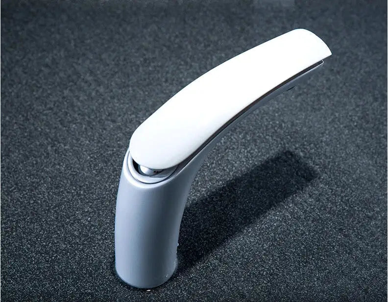 Modern white ceramic basin faucet with sleek curved spout and polish chrome accents in brass baking finish by decorbites