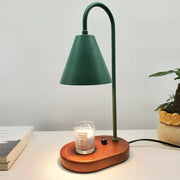 A sleek matte green electric candle lamp warmer with curved neck and wooden base holding a glass candle