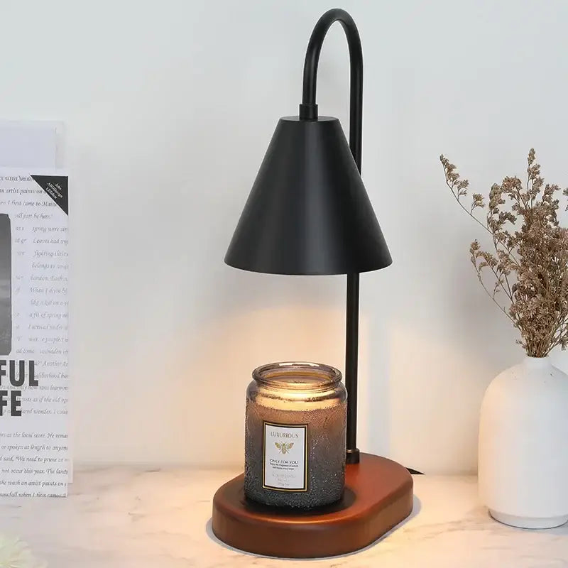 Black metal electric candle lamp warmer with sleek curved arm and conical shade on wooden base for bedroom use