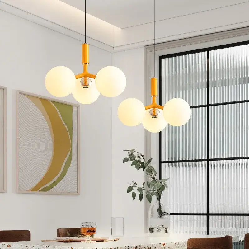Modern matte red decorbites glass ball pendant lighting fixture with warm yellow metal frame and three frosted glass globe bulbs