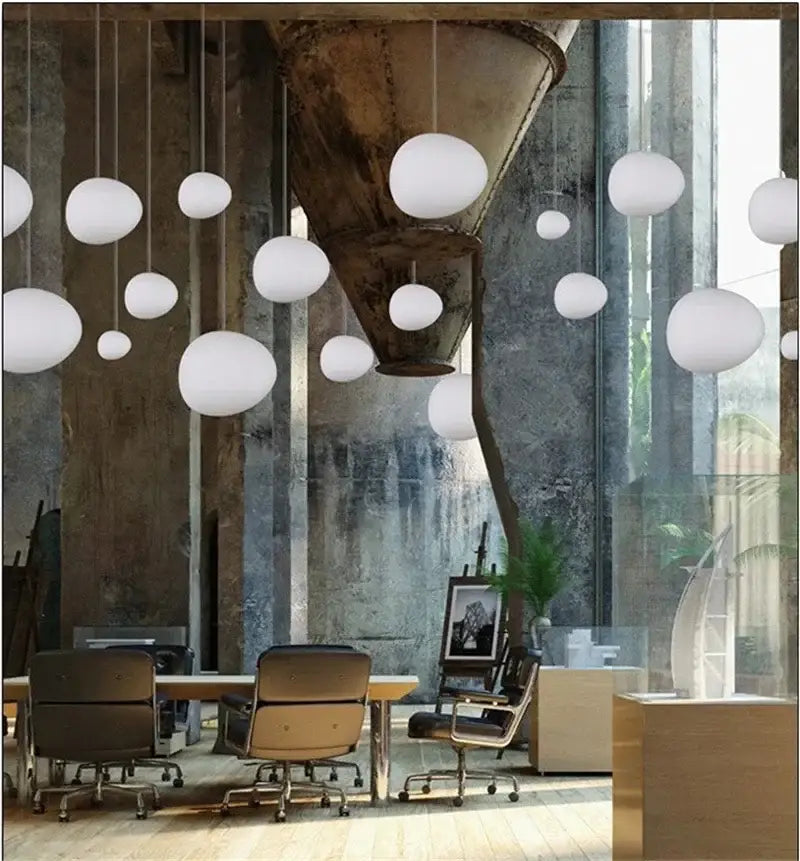 Modern matte white glass pendant light with spherical design hanging in an industrial space for dining room decorbites gregg glass pendant