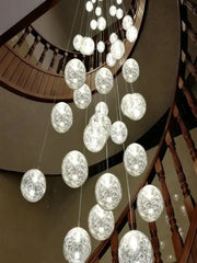 A modern decorbites crystal ceiling chandelier with spherical glass orbs and delicate wire mesh emitting soft white light