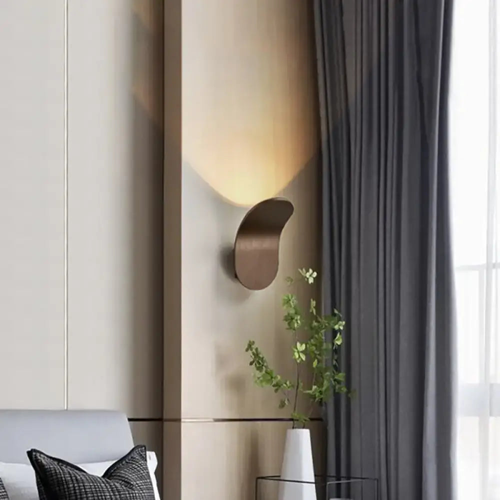 Modern metal bracket wall light in black gold coffee finish with sleek bronze-toned curved design casting warm light