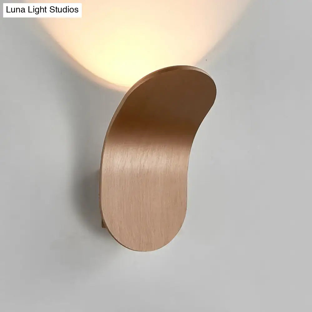 A sleek brushed copper wall light with metal bracket in black gold coffee finish providing warm bedroom lighting