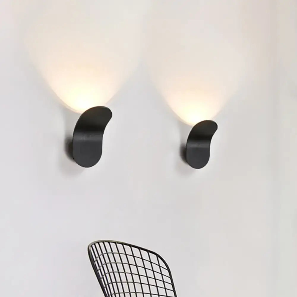 Two sleek black gold coffee metal bracket wall lights with curved minimalist design emit warm glow for bedroom use