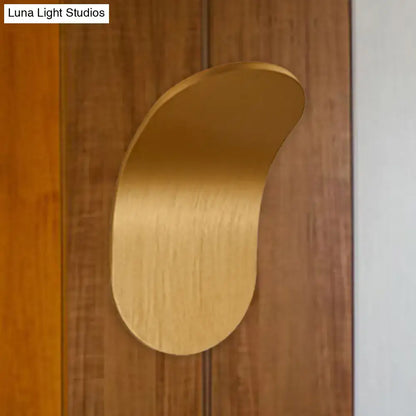 A sleek brushed gold metal bracket wall light with a curved leaf design in black gold coffee finish for bedroom use