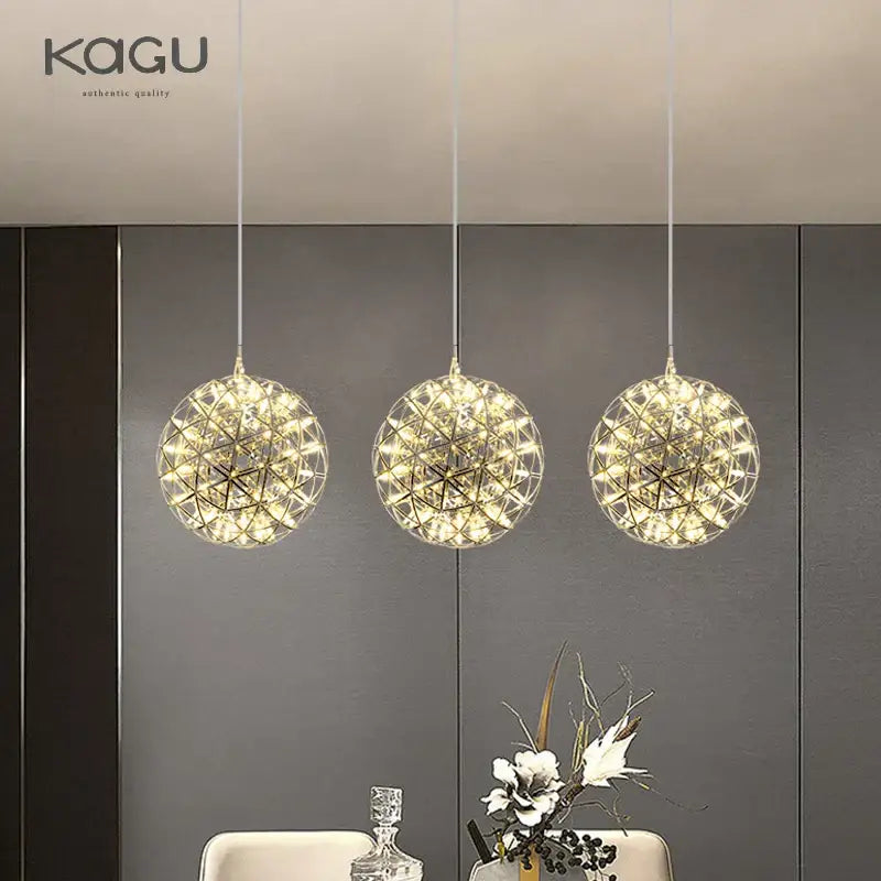 Three gold-toned crystal ball fireworks pendant lights with geometric wireframe design for living room illumination