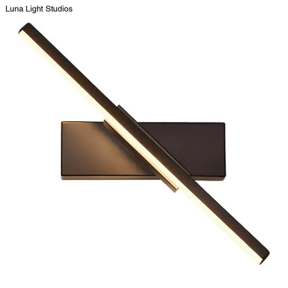Modern metallic black linear vanity wall sconce with two intersecting led bars emitting a warm glow
