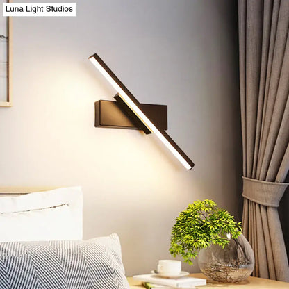 Modern metallic black linear vanity wall sconce with sleek angular design and warm LED light for bathroom use