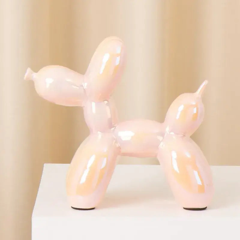 Glossy pink ceramic balloon dog statue with smooth reflective surface and black rubber feet for modern living room decor