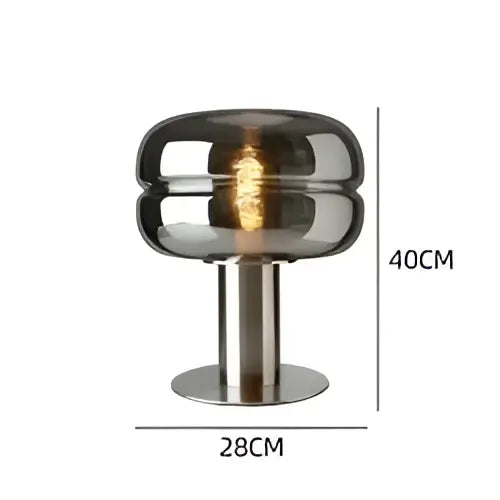 A sleek modern metallic glass table lamp with a brushed base and smoked dome ideal for elegant bedroom table lighting