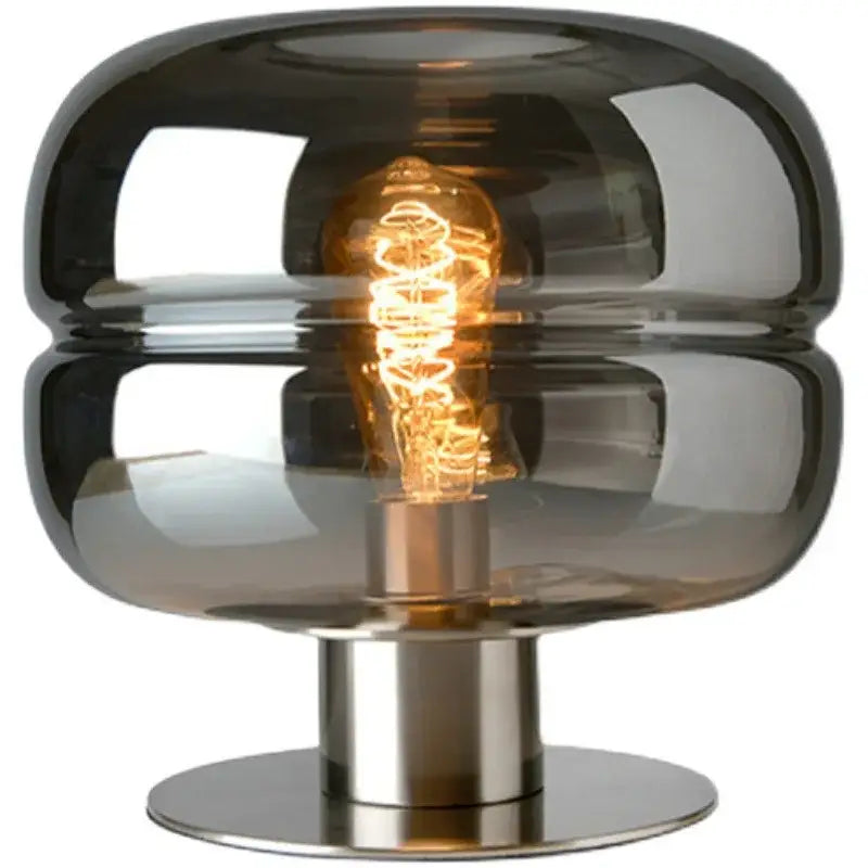 A sleek modern table lamp with dark smoked glass dome and polished stainless steel base for elegant bedroom table lighting