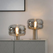 Two modern metallic glass table lamps with frosted reflective domed shades for elegant bedroom table lighting