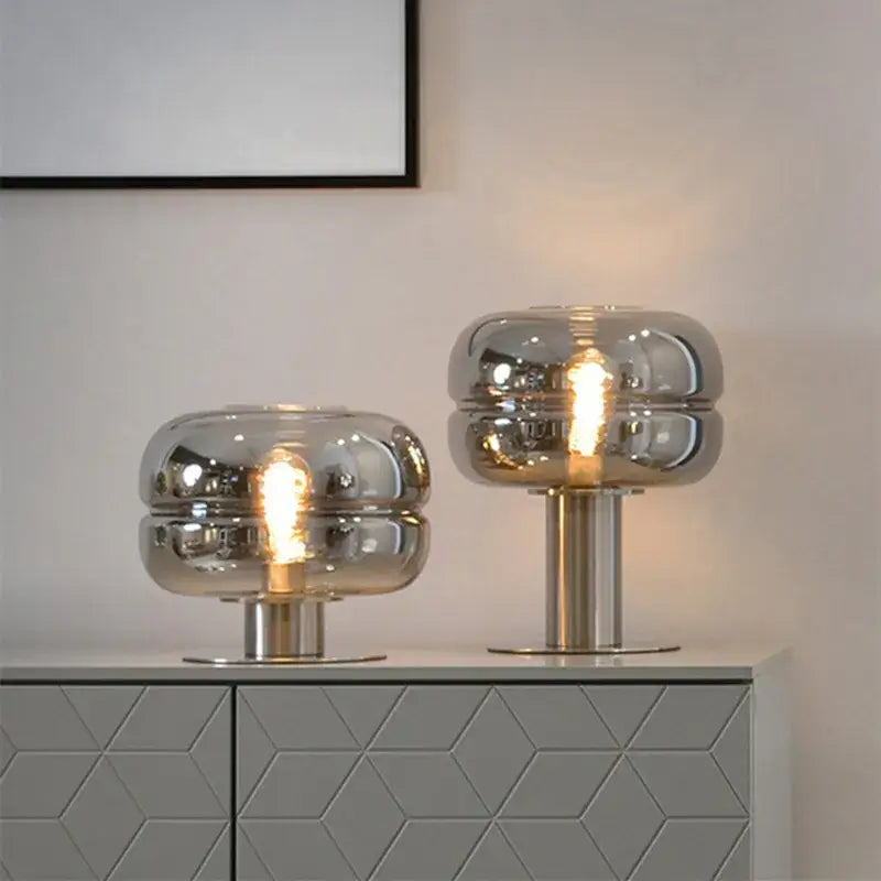 Two modern metallic glass table lamps with frosted reflective domed shades for elegant bedroom table lighting