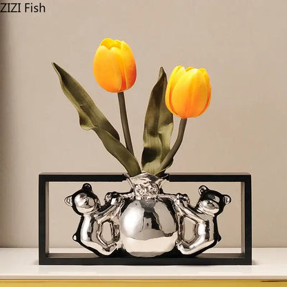Modern metallic silver ceramic vase shaped like a globe held by bears with vibrant orange artificial flowers decorbites elegant square