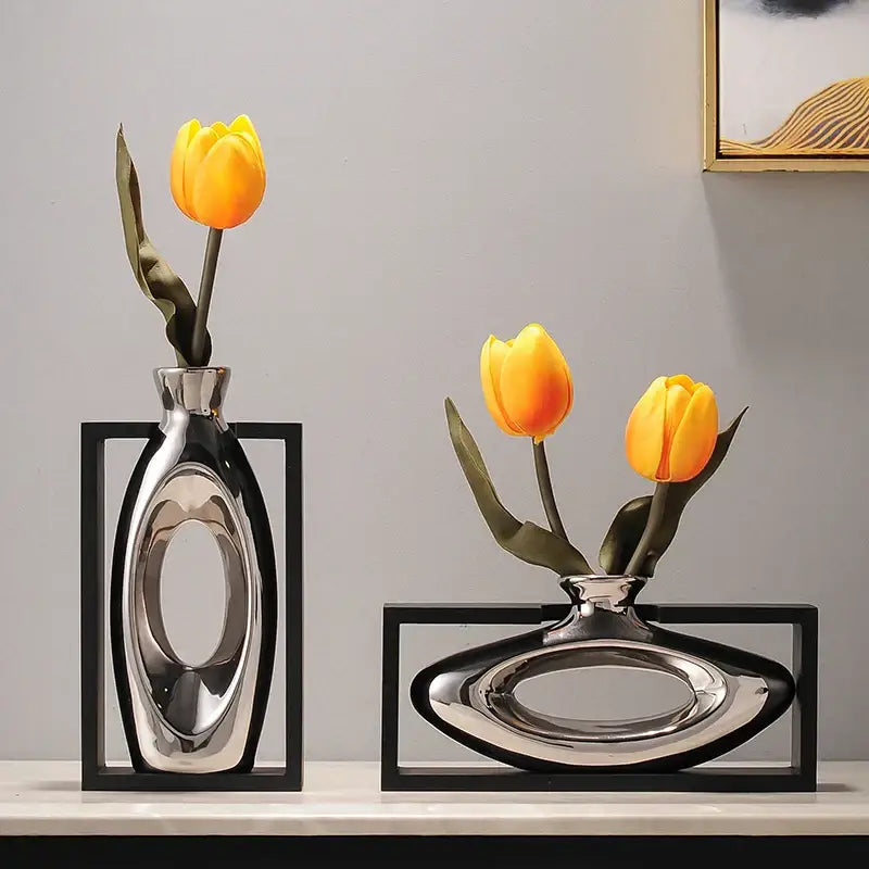 Two sleek silver ceramic vases with oval cutouts and artificial yellow tulips from decorbites elegant square decor