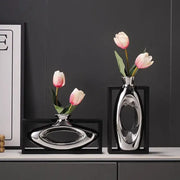 Modern metallic oval ceramic vase with shiny reflective surface and artificial flowers for decorbites elegant square desk decor