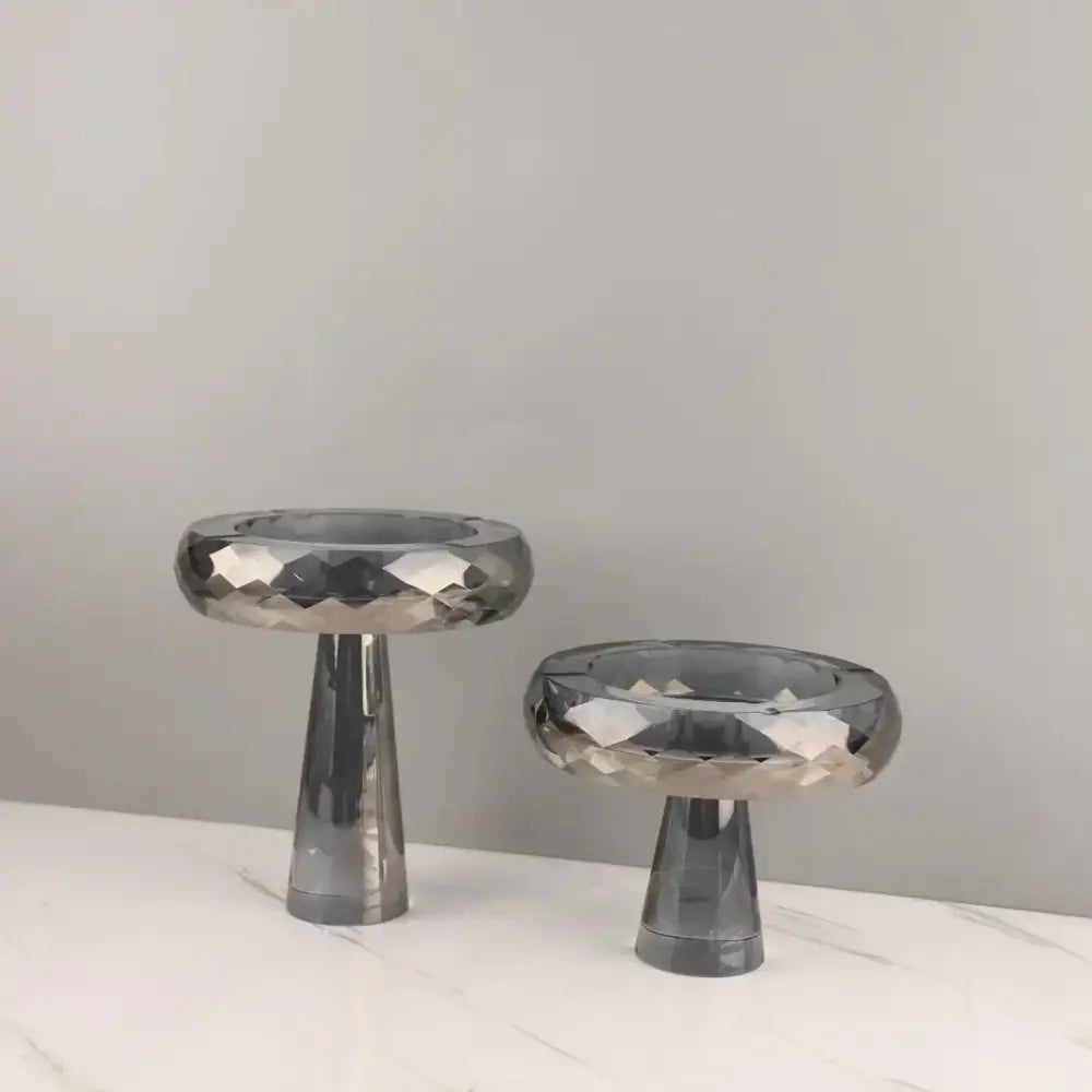 Two sleek faceted gray glass candle holders with a modern minimalist design complement decorbites geometric glass fruit bowl decor